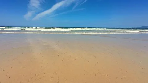 A Serene Beach View Featuring Gentle Waves, Sparkling Clear Sky, and Relaxing Stock Photos