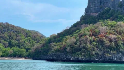 Serene beach view of a lush island with great rock in Thailand Stock Footage 294119009
