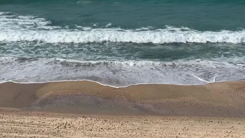 A serene beach with waves chasing each other toward the shore Stock Footage 294723063
