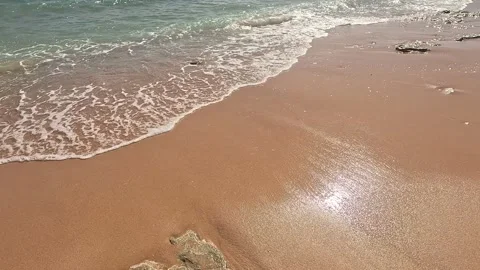 A Serene Beachfront Experience: Gentle Waves, Soft Sand, and Sunlight Reflecting Stock-Footage 330100351