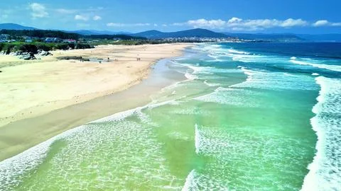 A Serene Beachscape featuring Crystal Clear Waters stretching across Golden Stock Photos