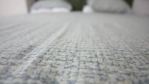 A Serene Bedroom Featuring Subtle and Elegant Patterned Bedding Stock Footage 294279649