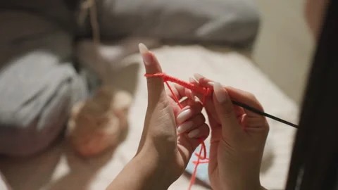 Serene bedtime crafting session, calm woman creating stitches by soft lamp light Stock Footage 329466656