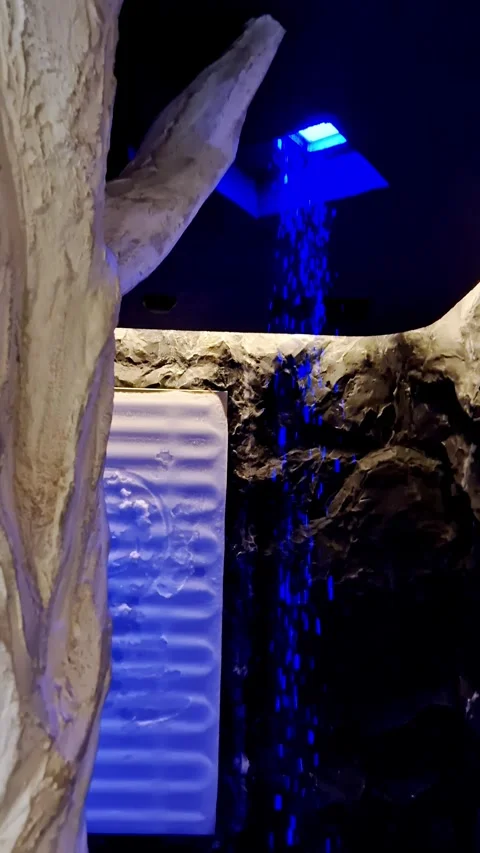Serene Blue Waterfall Shower Experience Inside a Refreshing Ice Cave Stock Footage 338994714