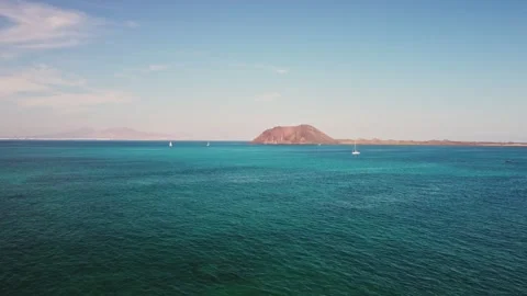 Serene blue waters and distant island under bright sky Stock Footage 307642816