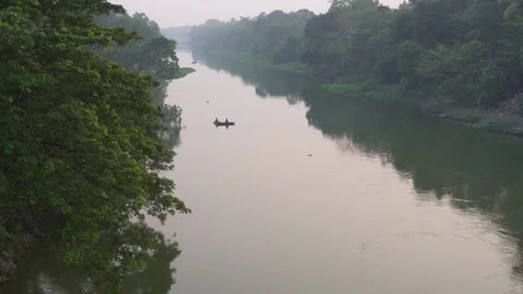 Serene Boat Gliding on Treelined River Stock Footage 326150153