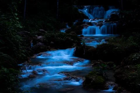 Serene Cascading Waterfall Flows Through Lush Tropical Jungle At Night Long.. Stock Photos
