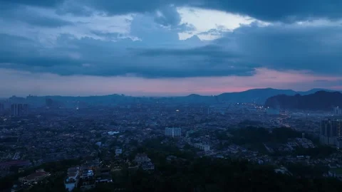 Serene Cityscape at Dusk with Dramatic Clouds and Hills Stock Footage 312143354