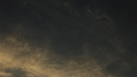 A Serene Cloudy Sky enveloped in Warm Golden Hues, Radiating Unmatched Beauty at Stock Footage 318065959