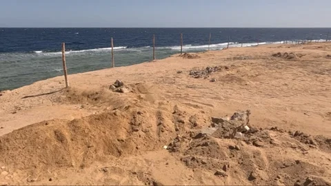 A Serene Coastal Landscape Featuring Sandy Terrain with a Turquoise Sea and Stock Footage 330102091