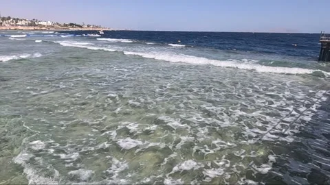 Serene Coastal Scene: Capturing the Tranquility of Gentle Waves Lapping Against 库存影片 330100530