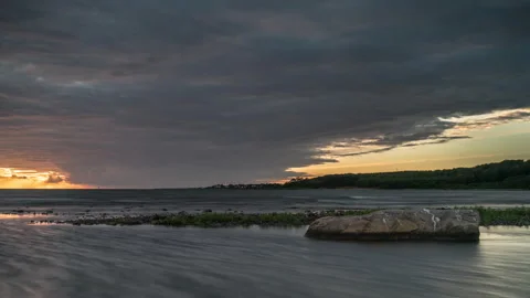 Serene Coastal Sunset with Dark Clouds Stock Footage 303940936