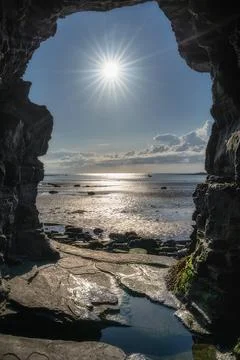 A Serene Coastal View Captured Through a Natural Rock Arch, Enhanced by the Stock Photos
