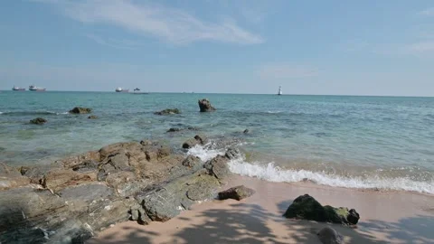 Serene Coastal View with Rocks and Ships on Calm Blue Water Stock Footage 296479662