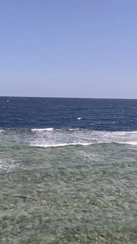 A Serene Coastal View: Tranquil Waves and Crystal Clear Waters Under a Bright 库存影片 330097210
