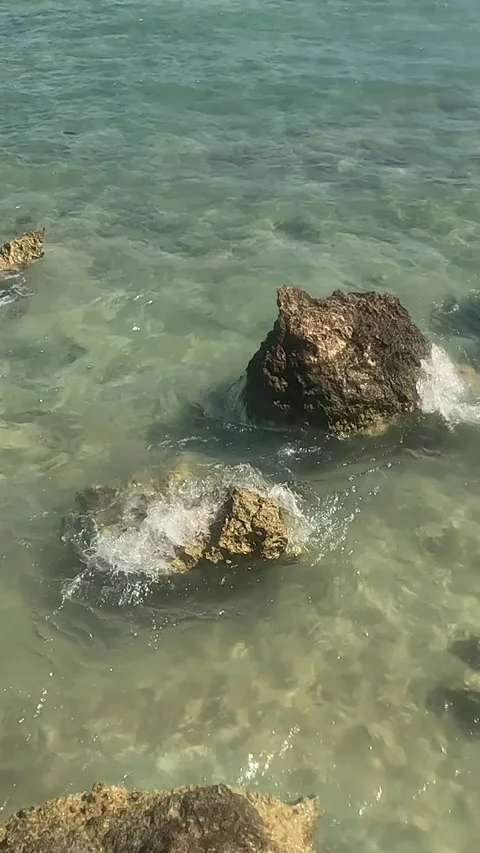 Serene Coastal Waters: A Tranquil View of Clear Aquatic Depths and Rock Stock Footage 332145813