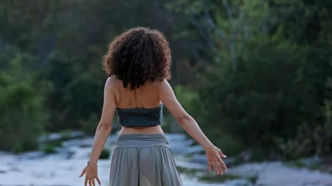 A Serene Dance by the Water: Capturing the Graceful Movements of a Woman Amidst Stock Footage 317951367