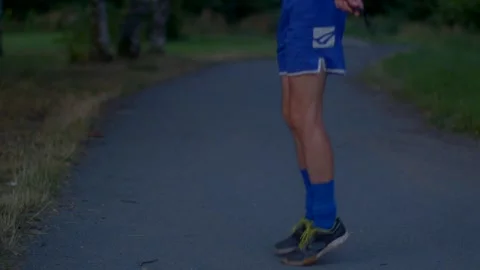 Serene dusk setting showing man in blue shorts performing jump rope on trail Stock Footage 321029876