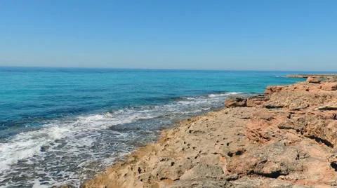 Serene Emerald Sea, Waves Breaking Into Red Rocks Stock Footage 49882048