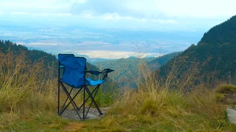 Serene empty camping chair overlooking majestic mountain vista Stock Footage 310139005