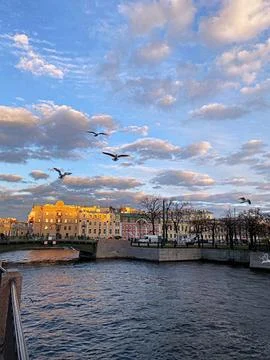 Serene Evening Over the River With Clouds and Seagulls in Historic City Foto stock