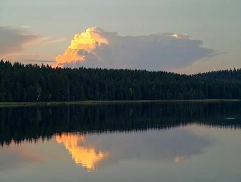 Serene evening scene with shining cloud, calm waters mirror bright cloud Stock Photos