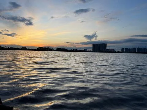 A serene evening sunset over a large pond Stock Photos