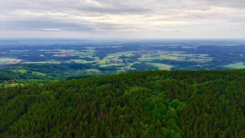 Serene expansive aerial view of rolling hills and fields under a cloudy sky in Stock Footage 342359402