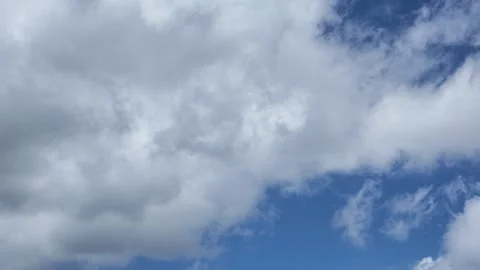A serene, expansive sky with fluffy white clouds in continuous movement across 库存影片 338266525