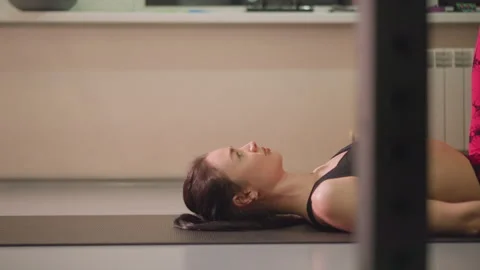 Serene female instructor lying on mat during gentle exercise session, Indoor Stock Footage 346378609