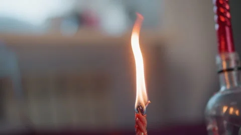 Serene flame illuminates tranquil space. Warm candle flickers beside clear glass Stock Footage 347527915