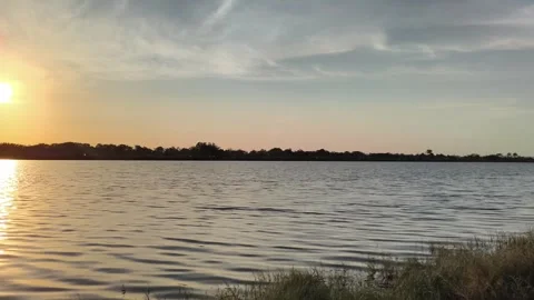 Serene Golden Hour Sunset Reflection on Calm Lake Ripples Video stock 341506513