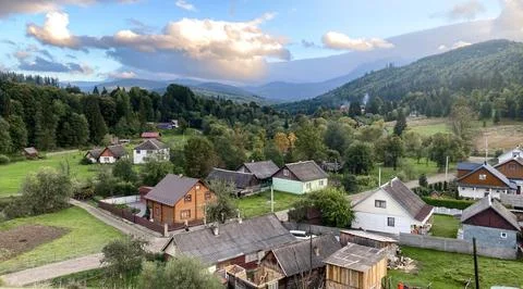 A serene, high-angle view of a small, traditional village nestled in a lush, Stock Photos