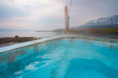 Serene Hot Spring Spa with Snow-Capped Mountains and Coastal View in Iceland Stockfoto's