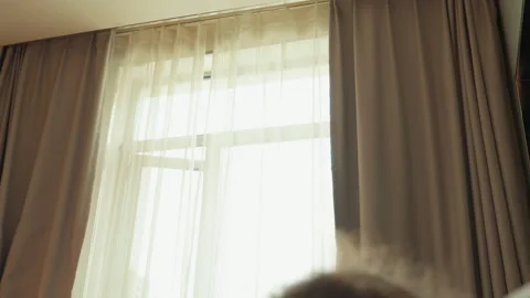 Serene hotel room ambiance with soft light and peaceful guest. Calm morning Stock Footage 334071069