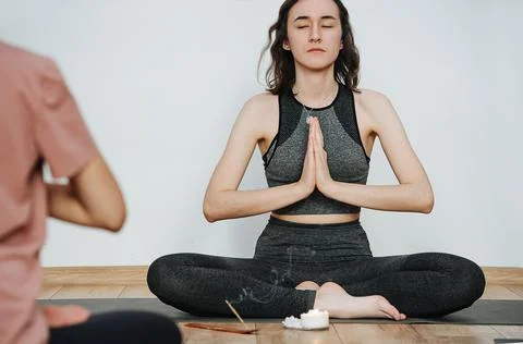 Serene instructor practicing yoga, meditating eyes closed. Burning incense stick Stock Photos
