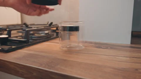 Serene kitchen setup with unfilled glass container and wood surface. Calm home Stock Footage 337465107