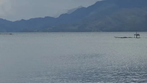 A serene lake with distant mountains under a cloudy sky. Stock Footage 291379521