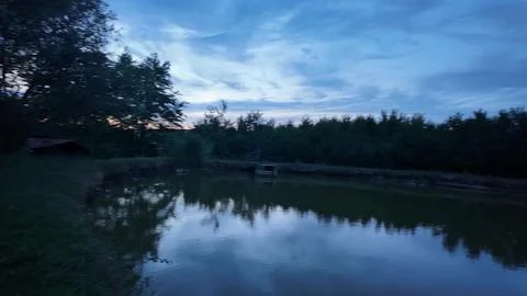 Serene lake reflection at dusk with dramatic cloudy sky overhead Fotos Stock