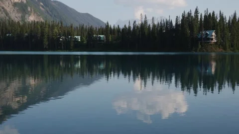 Serene Lake Reflection with Forest and Mountain View at Dusk Stock Footage 255626575