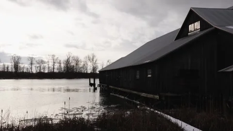 Serene Lakeside Barn on a Cloudy Day with Reflective Water Stock Footage 271199072