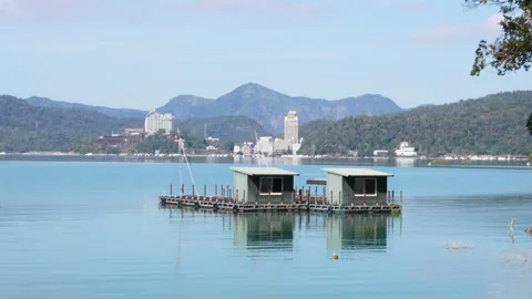 Serene Lakeside View with Floating Huts and Distant Mountains Video stock 268907627