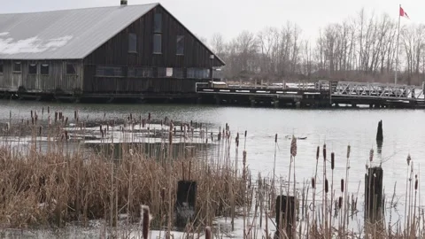 Serene Lakeside View with Rustic Boat House and Pier Stock Footage 271198698