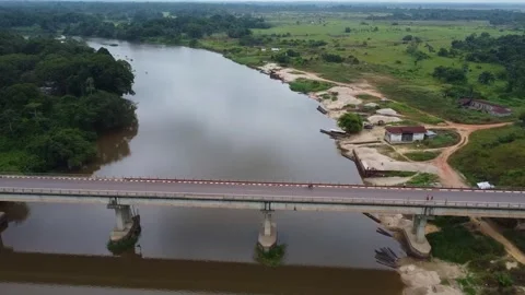 Serene Landscape Featuring a Bridge Crossing a Wide River, Bordered by Lush Stock Footage 316465944