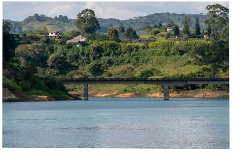 Serene landscape featuring a bridge spanning tranquil waters, nestled amids.. Stock Photos