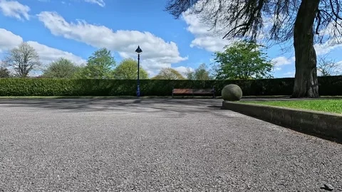 Serene low-angle cinematic view of a walking pathway in Lister Park, Bradford Stock Footage 333793945