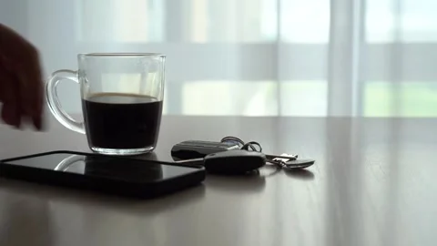 A Serene Morning Scene Featuring a Coffee Cup and Essentials on a Wooden Table Stock Footage 346740566