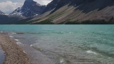 Serene Mountain Lake with Pine Forest and Pebble Shoreline Stock Footage 255626465