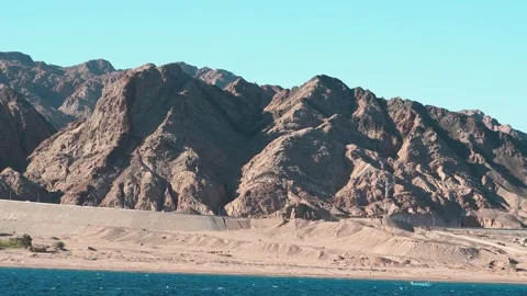 A serene mountain landscape featuring a blue sky with clouds over a rocky desert Stock Footage 329236985