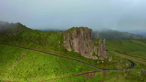 Serene mountain road winding through green hills and rock formations. Stock-Footage 341250176